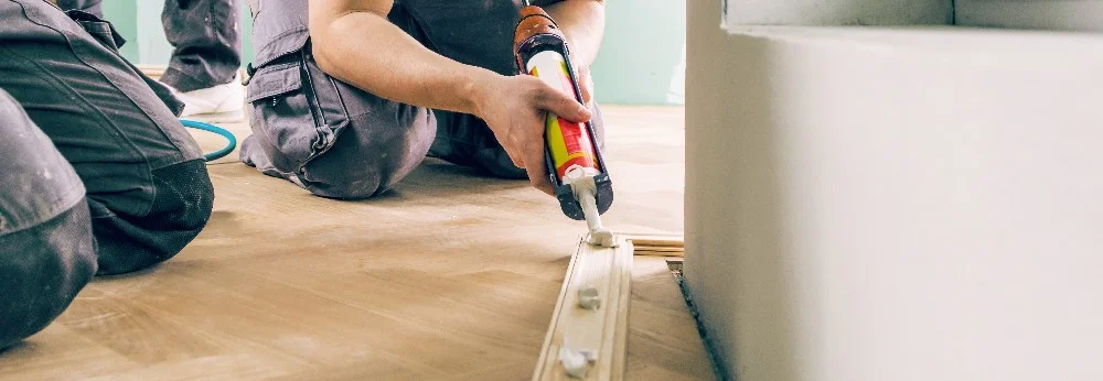 Person bringt Dichtmittel an